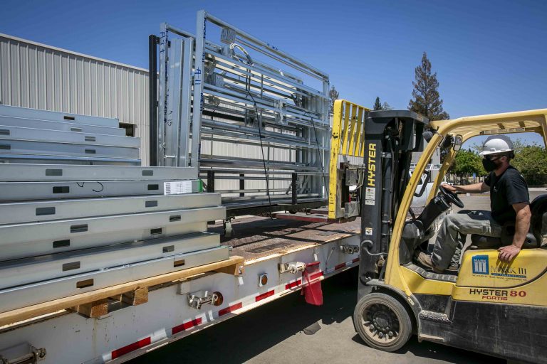 M-walls are loaded onto a truck for delivery.