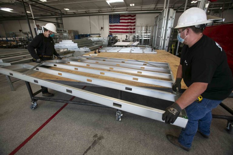 M3C manufacturing facility workers move an m-wall to a new station to complete the build.
