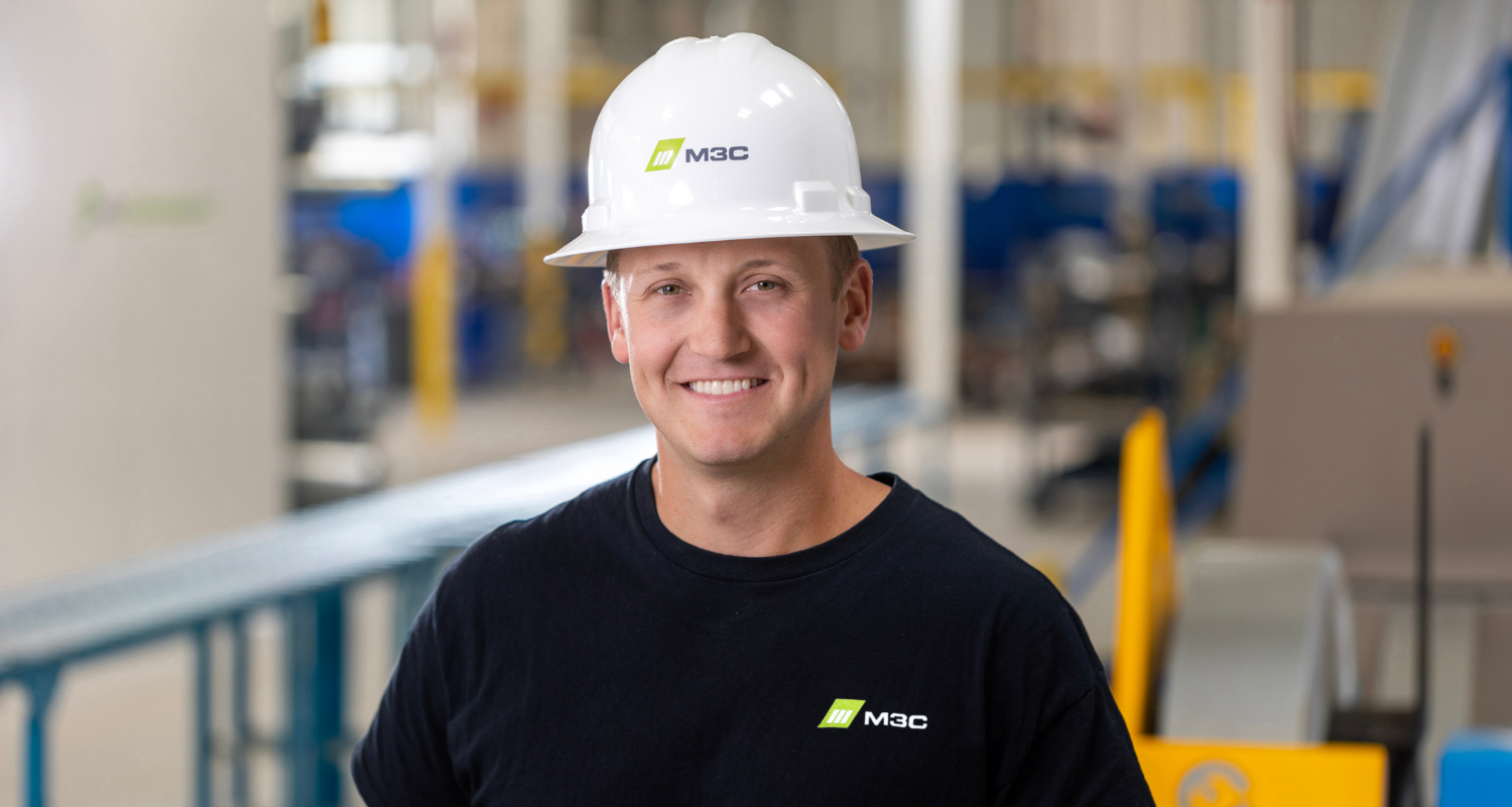 Headshot photo of Caleb Rugg in M3C's manufacturing facility.